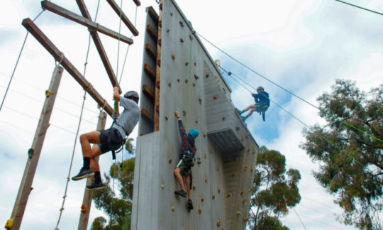 campers climbing and rappelling down from the 30 ft climbing wall