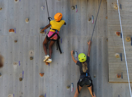 two girls climbing together on the climbing wall